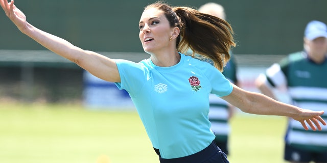 A close-up of Kate Middleton wearing a blue shirt and dark pants