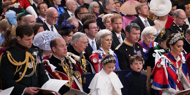 Prince Harry sitting within a crowd during his fathers coronation