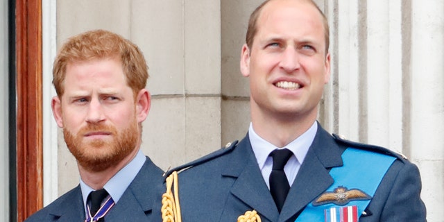 Prince William and Prince Harry in their uniforms looking ahead from Buckingham Palace