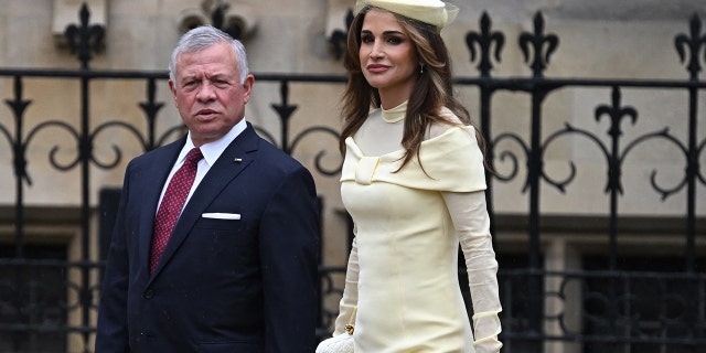 Jordans King Abdullah II Ibn Al Hussein in a suit next to queen rania in a yellow dress