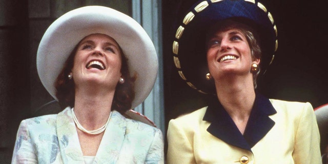 Sarah Ferguson and Princess Diana looking up with their hats on