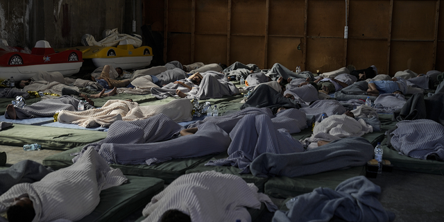 Greece migrant boat sinking survivors sleep in warehouse