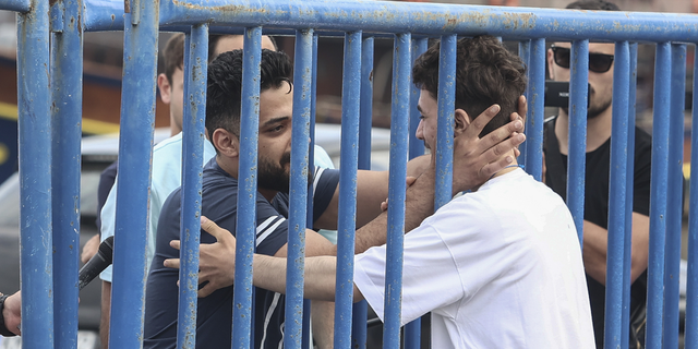 Migrant from Syria embraces brother after surviving sinking of boat