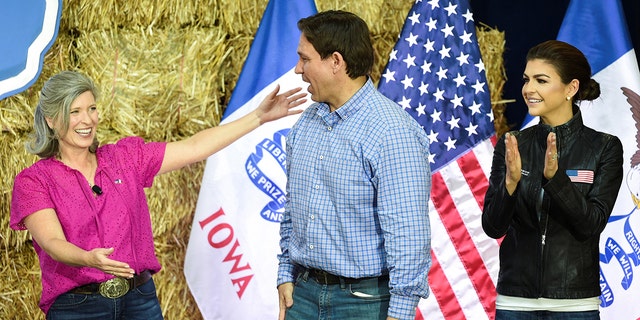 Joni Ernst stands near Florida Gov. Ron DeSantis and his wife, Casey DeSantis