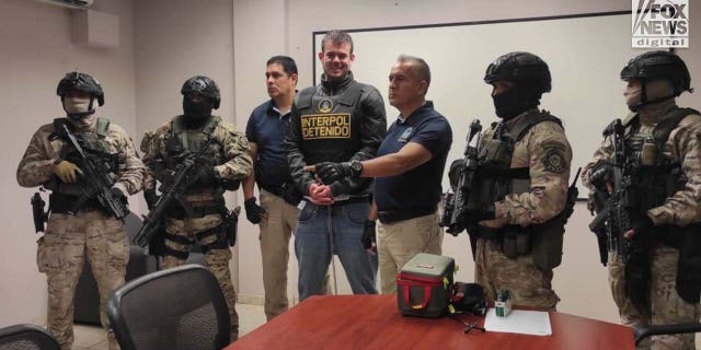 Joran van der Sloat is surrounded by armed guards.