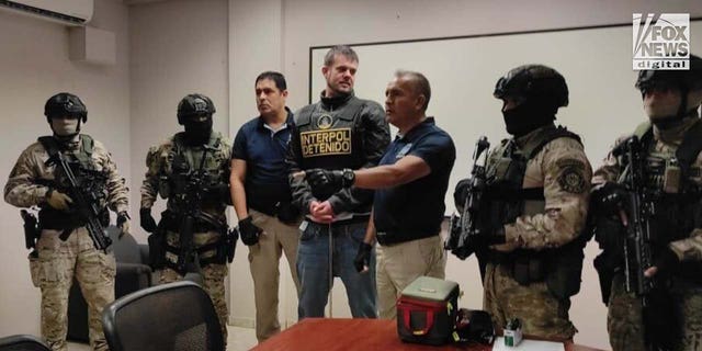 Joran van der Sloot is surrounded by armed guards.