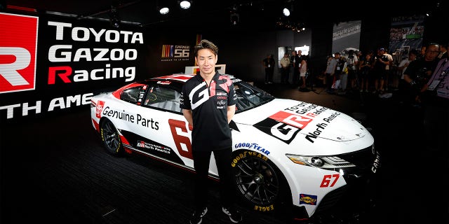 Kamui Kobayashi posa junto a su auto