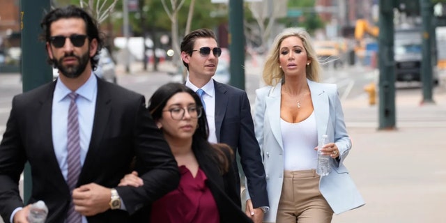 Lawrence and Bianca Rudolph's son, Julian (left), and daughter, Anabianca (back right) walk into a Denver courthouse