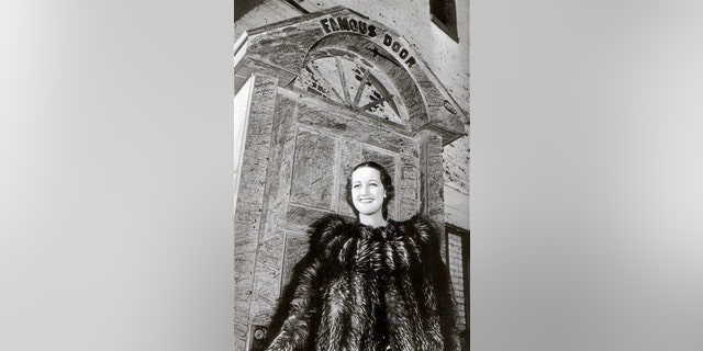 Actress Dorothy Lamour wearing a fur coat in front of The Famous Door