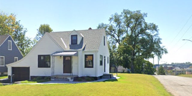 A white home with a green lawn.