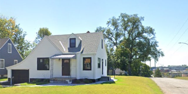 A white home with a green lawn.