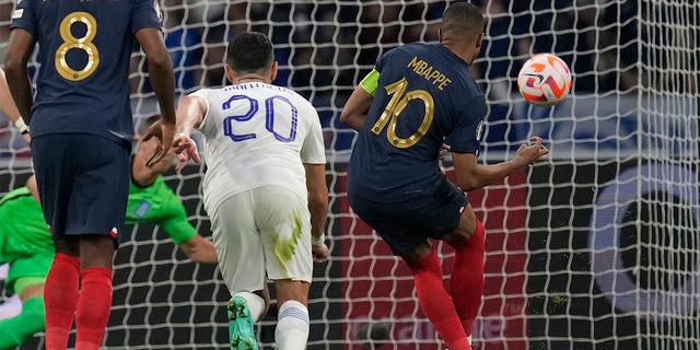 Kylian Mbappé shoots ball