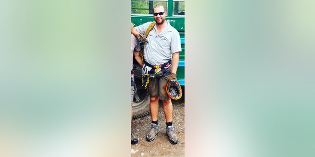 Kevin Metzger in sunglasses, holding climbing gear