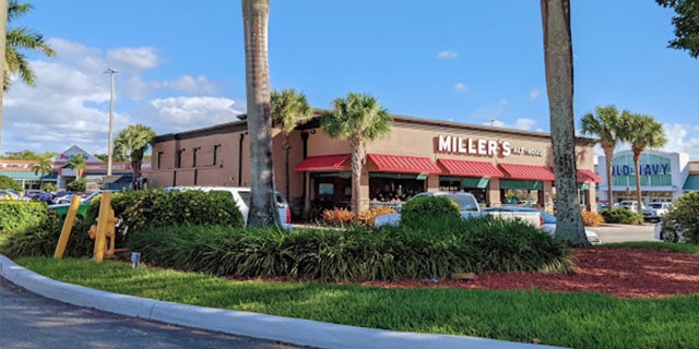 A single story restaurant flanked by palm trees.