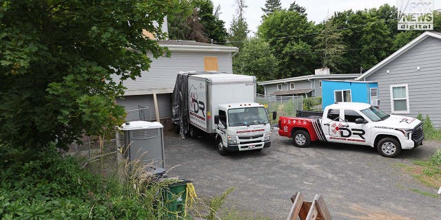 Trucks labeled Disaster Recovery parked as workers went in and out of the King Road home in Moscow idaho