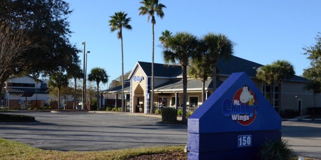 The exterior of Mr. Chubby's with palm trees flanking the entrance.