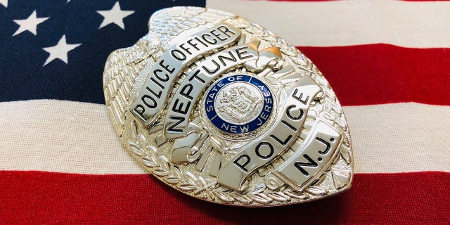 Neptune Township police badge in front of American Flag