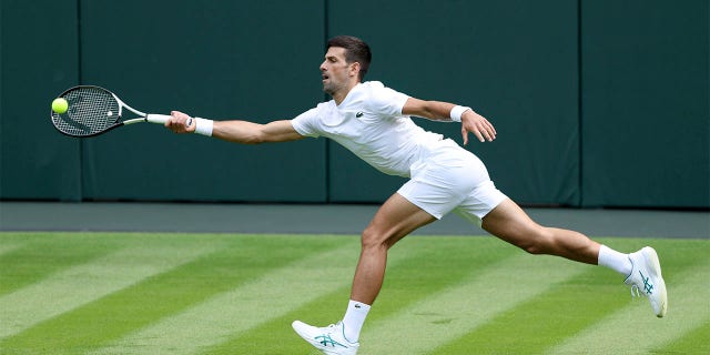 Novak Djokovic reaches to shoot
