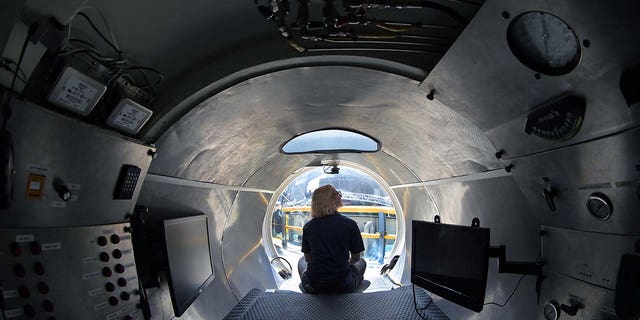 A woman sits inside an OceanGate submersible