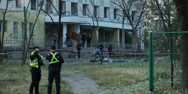 Officers review damaged building in Kyiv