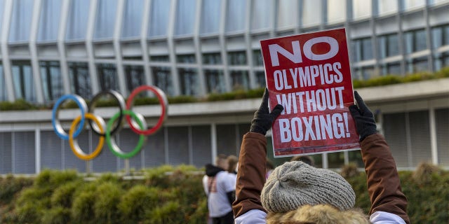 Woman holds poster in support of boxing