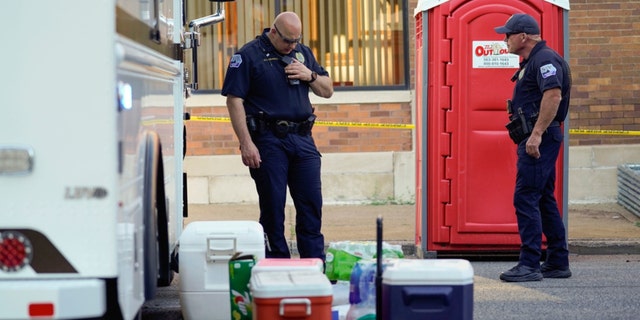 Police officers stand at the scene