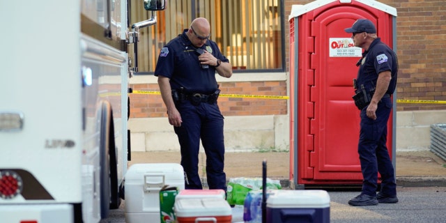 Police officers stand at the scene