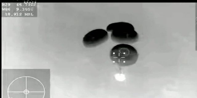 The SpaceX Dragon capsule is seen with parachutes deployed