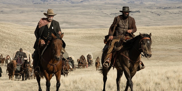Sam Elliott and Tim McGraw riding horses in Western wear