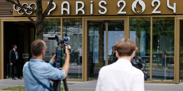 Reporters outside an Olympic Games office