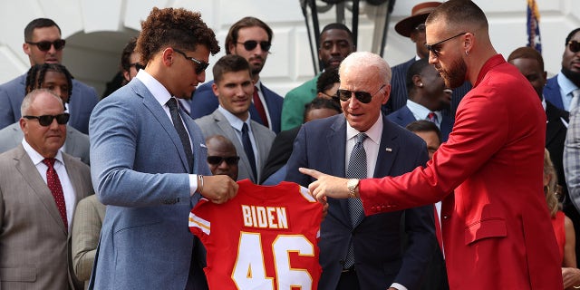 Patrick Mahomes holds jersey for Joe Biden