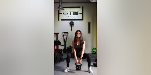 Fit personal trainer works out in a gym