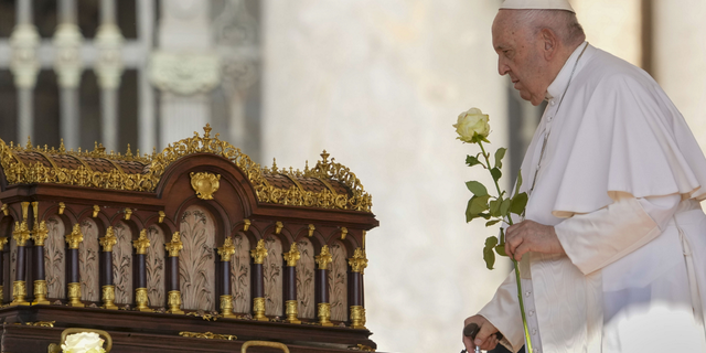 Pope Francis prays in front of relics at Vatican