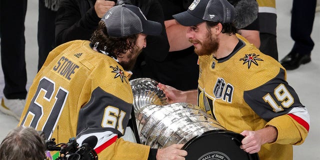 Mark Stone hands cup to Reilly Smith