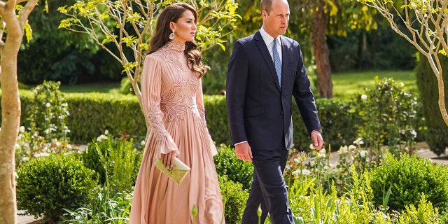 Kate Middleton in a blush gown next to Prince William in a blue suit