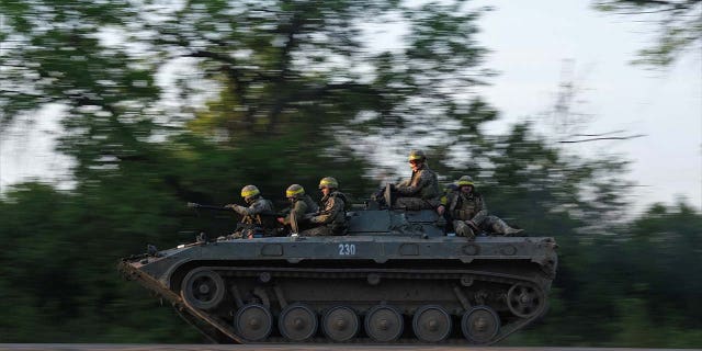 Ukrainian soldiers ride on a BMP infantry fighting vehicle toward Bakhmut,