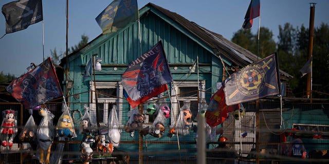 flags, including those of the Wagner private mercenary group, for sale on a road outside Moscow.