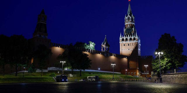 Law enforcement vehicles are seen in front of the Kremlin's Spasskaya Tower