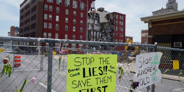 Flowers and signs are posted at the where on Sunday an apartment building partially collapsed in Davenport