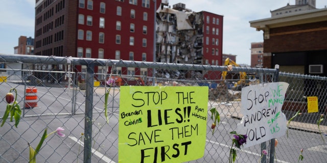Flowers and signs are posted at the where on Sunday an apartment building partially collapsed in Davenport