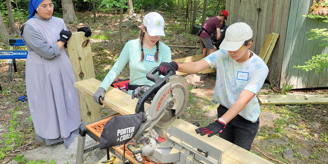 Two girls working a saw