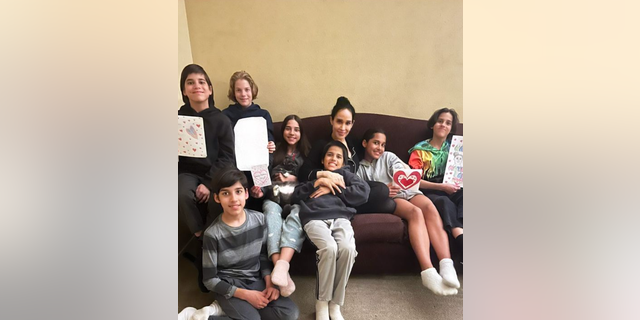 Nadya Suleman sits on the couch with seven of her kids, several holding cards for Mother's Day