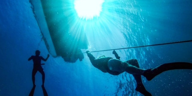 Two people swimming in deep water