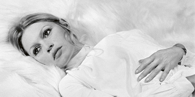 Brigitte Bardot in bed wearing white
