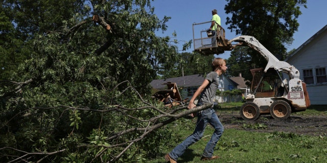 An Arkansas man helps move debris from his home