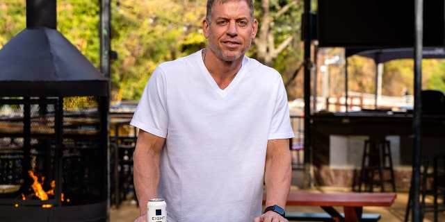 Troy Aikman holds a beer