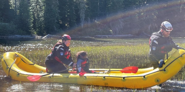 rescuers with child on watercraft