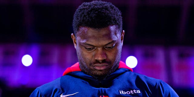 Zion Williamson listens to the anthem