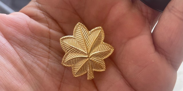 Man holds the golden leaf pin of major in his hand