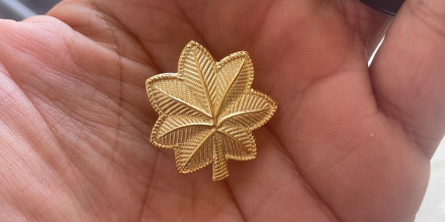 Man holds the golden leaf pin of major in his hand